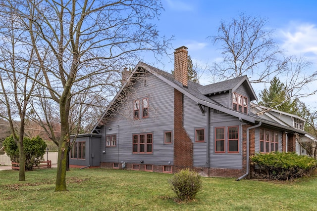 view of side of property with a chimney and a yard