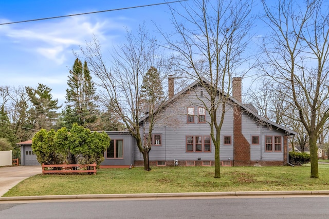 view of front of property with a chimney, driveway, and a front lawn