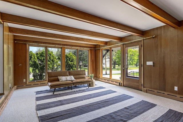 living room with beamed ceiling, carpet, a baseboard radiator, and wooden walls