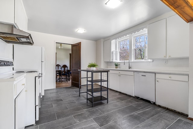 kitchen featuring white appliances, under cabinet range hood, a sink, light countertops, and white cabinets