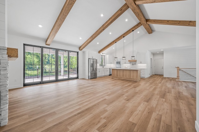 unfurnished living room with beam ceiling, high vaulted ceiling, and light wood-type flooring