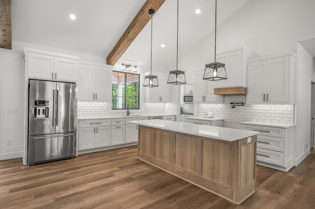 kitchen featuring white cabinets, a center island, backsplash, and appliances with stainless steel finishes