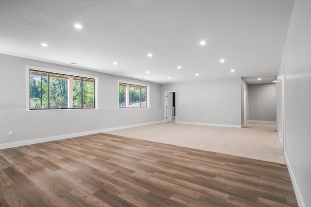 carpeted empty room featuring a textured ceiling