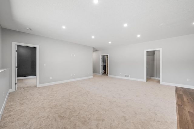 unfurnished room with a textured ceiling and light wood-type flooring