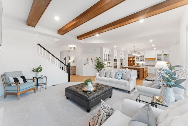 carpeted living room with beam ceiling and an inviting chandelier