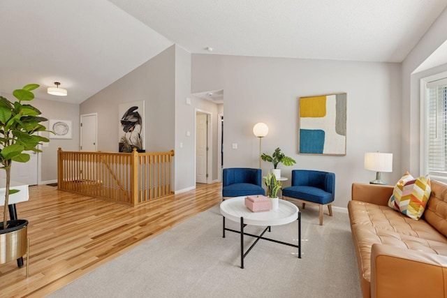living room with wood finished floors, baseboards, and high vaulted ceiling