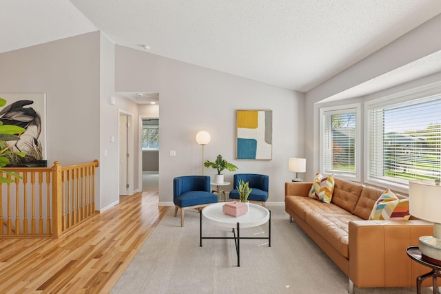 living room with vaulted ceiling, wood finished floors, and baseboards