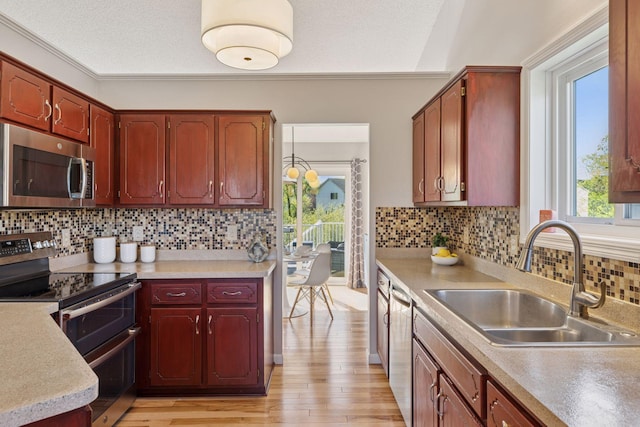 kitchen with light countertops, plenty of natural light, stainless steel appliances, and a sink
