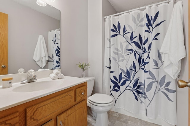 bathroom featuring a textured ceiling, toilet, stone finish flooring, a shower with shower curtain, and vanity