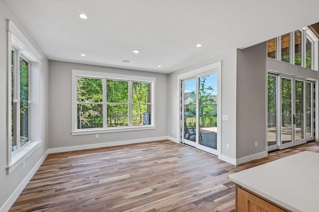 unfurnished living room with a wealth of natural light and hardwood / wood-style floors