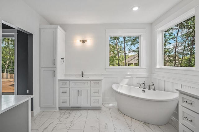 bathroom with a tub to relax in and vanity