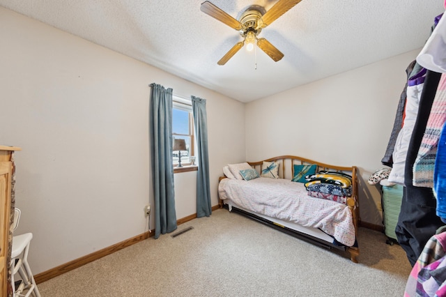 carpeted bedroom featuring a textured ceiling and ceiling fan