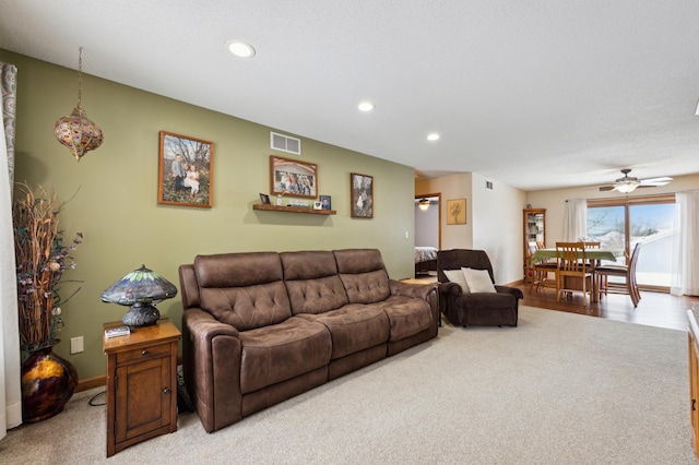 living room with ceiling fan and light colored carpet