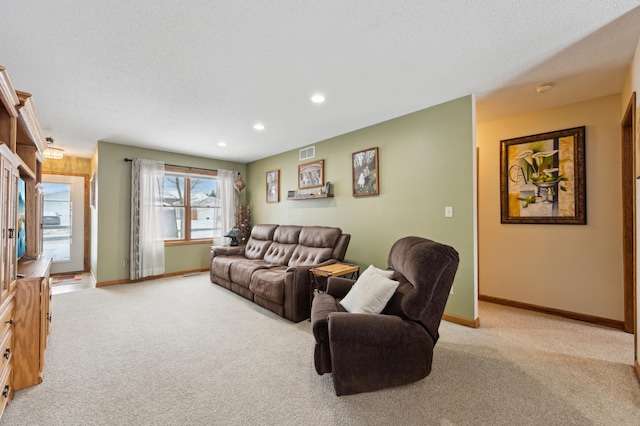 carpeted living room featuring a textured ceiling