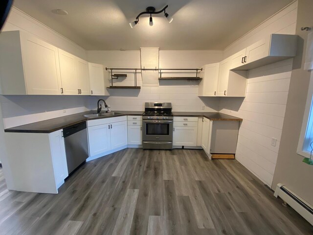 kitchen with stainless steel appliances, sink, a baseboard radiator, dark hardwood / wood-style floors, and white cabinetry