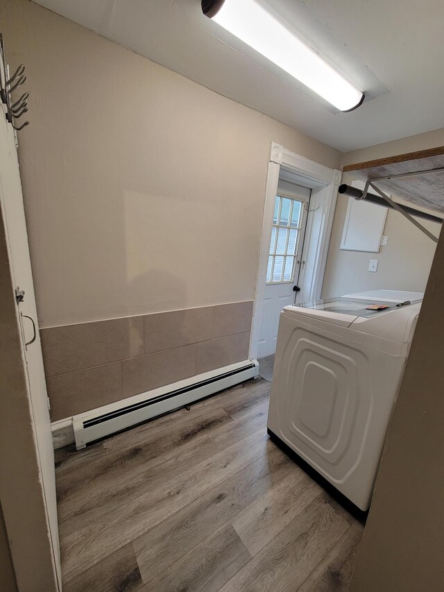 laundry room featuring washer / clothes dryer, light hardwood / wood-style flooring, and a baseboard radiator