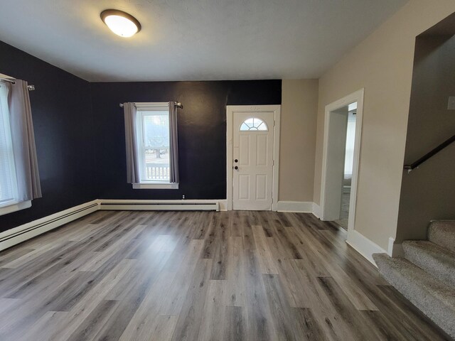 foyer with light wood-type flooring and baseboard heating