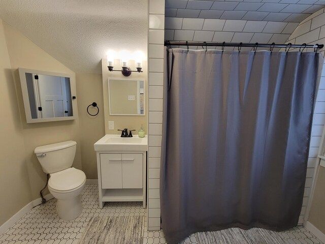 bathroom with a textured ceiling, vanity, toilet, and tile patterned floors