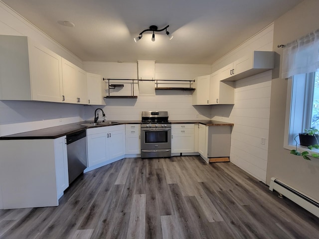 kitchen featuring appliances with stainless steel finishes, a baseboard heating unit, sink, white cabinets, and dark hardwood / wood-style floors