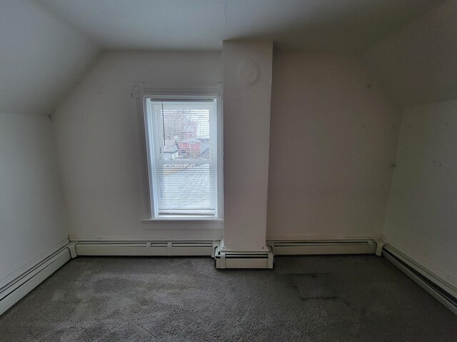 additional living space featuring carpet floors, vaulted ceiling, and a baseboard heating unit