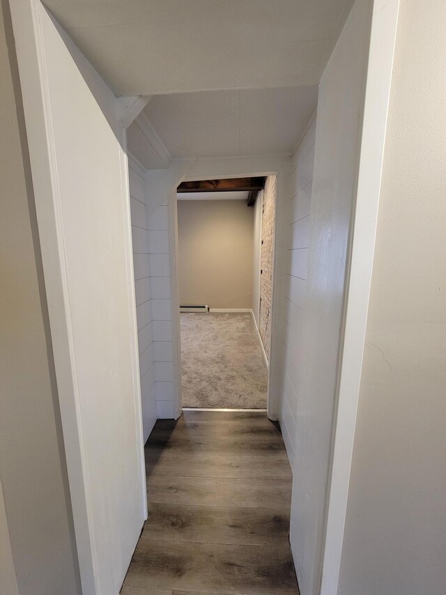 hallway with dark wood-type flooring and a baseboard heating unit