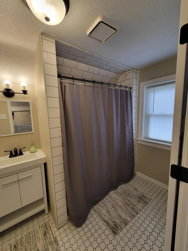 bathroom featuring vanity, a textured ceiling, and walk in shower