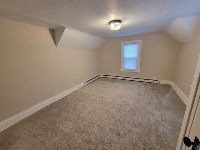 additional living space with baseboard heating, carpet floors, and vaulted ceiling