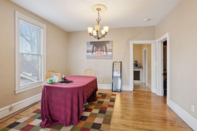 dining space with an inviting chandelier and hardwood / wood-style floors