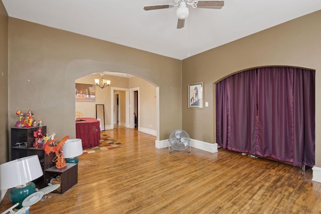 interior space featuring hardwood / wood-style flooring and ceiling fan with notable chandelier