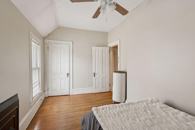 bedroom with wood-type flooring, ceiling fan, and vaulted ceiling