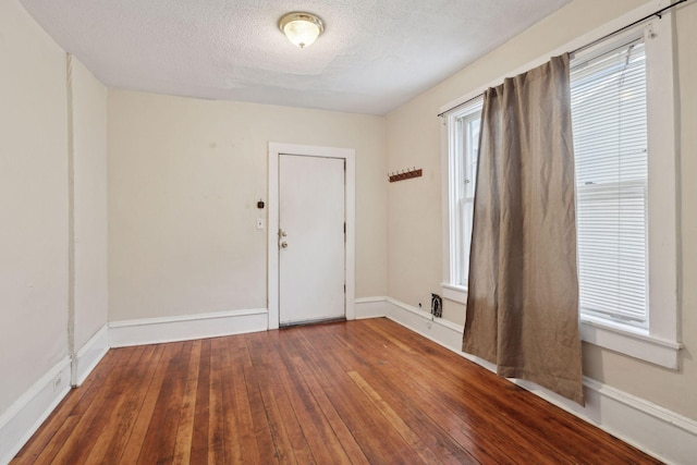 spare room with dark hardwood / wood-style flooring and a textured ceiling