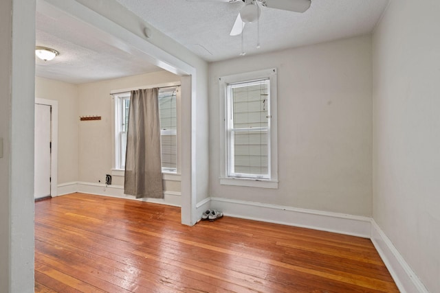 empty room featuring hardwood / wood-style flooring, ceiling fan, and a textured ceiling