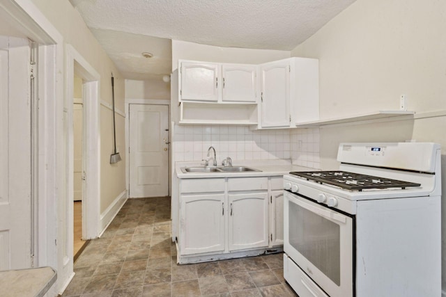 kitchen with sink, white range with gas stovetop, a textured ceiling, white cabinets, and backsplash