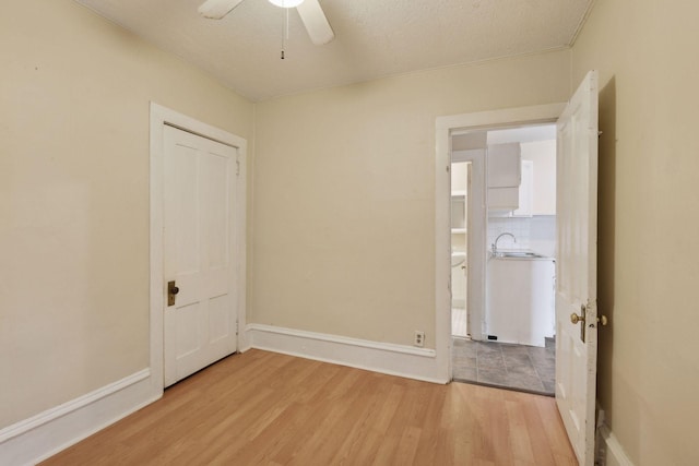 unfurnished bedroom with ceiling fan, sink, and light hardwood / wood-style flooring