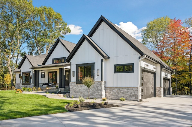 modern inspired farmhouse featuring a front lawn, covered porch, and a garage