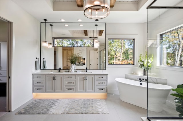 bathroom with tile patterned floors, vanity, beam ceiling, and a tub