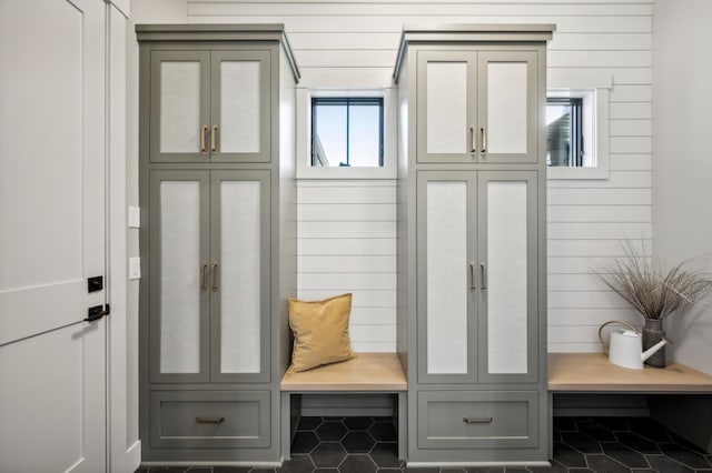 mudroom featuring tile patterned flooring and wooden walls