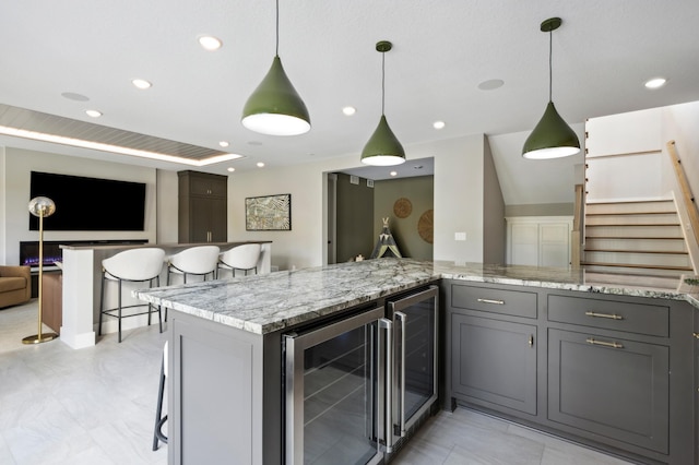 kitchen featuring wine cooler, pendant lighting, and gray cabinetry