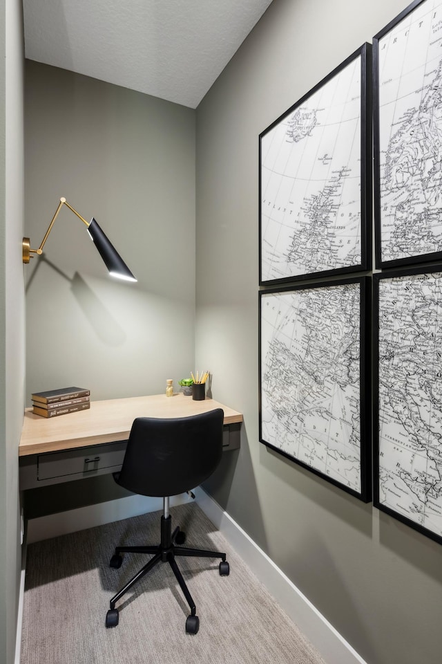 office area with built in desk and a textured ceiling