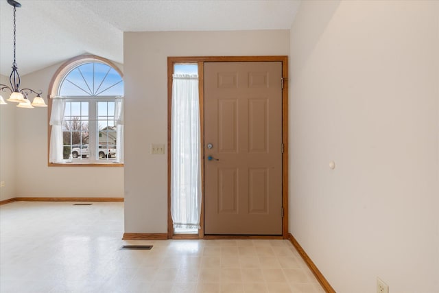 entrance foyer featuring a textured ceiling and a chandelier