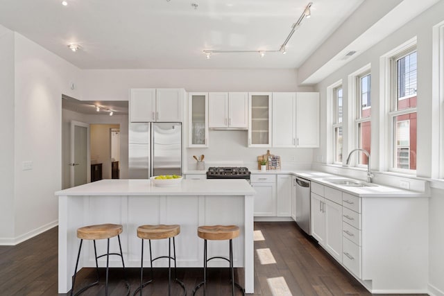 2825 Colfax Ave S Unit 211, Minneapolis, MN 55408 - kitchen with stainless steel appliances, rail lighting, a kitchen island, and white cabinetry