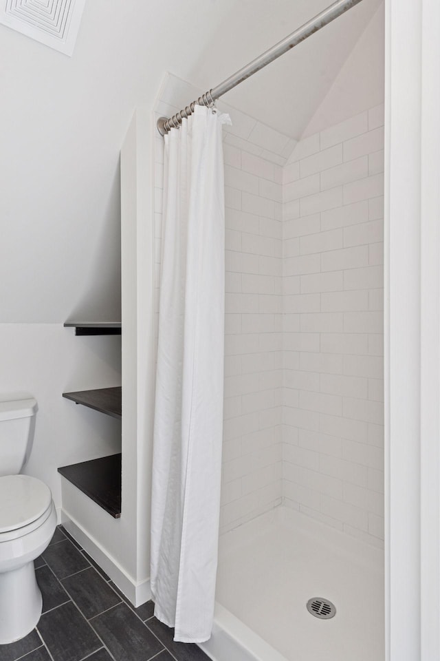 2825 Colfax Ave S Unit 211, Minneapolis, MN 55408 - bathroom featuring toilet, tile patterned floors, a stall shower, and vaulted ceiling