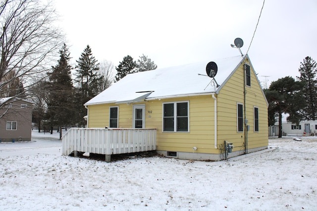 snow covered rear of property featuring a wooden deck