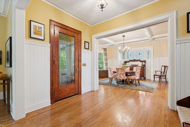 1941 James Ave S, Minneapolis, MN 55403 - dining space featuring a decorative wall, wainscoting, light wood-style flooring, a chandelier, and crown molding