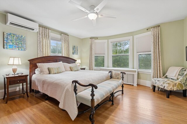 1941 James Ave S, Minneapolis, MN 55403 - bedroom with a wall unit AC, light wood-style flooring, multiple windows, and radiator heating unit
