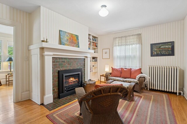 1941 James Ave S, Minneapolis, MN 55403 - living area featuring radiator, wood finished floors, wallpapered walls, a fireplace, and built in features