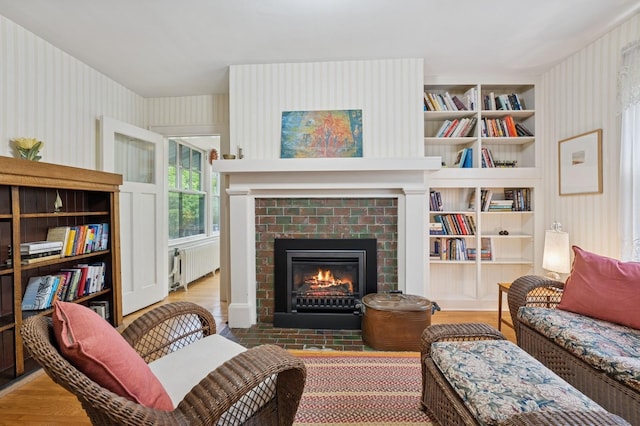 1941 James Ave S, Minneapolis, MN 55403 - sitting room with radiator heating unit, wood finished floors, a fireplace, wallpapered walls, and built in features