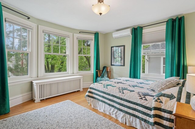 1941 James Ave S, Minneapolis, MN 55403 - bedroom with radiator heating unit, a wall mounted air conditioner, and multiple windows