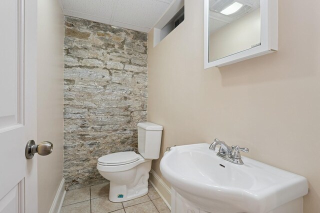 1941 James Ave S, Minneapolis, MN 55403 - half bathroom with tile patterned flooring, toilet, baseboards, a paneled ceiling, and a sink
