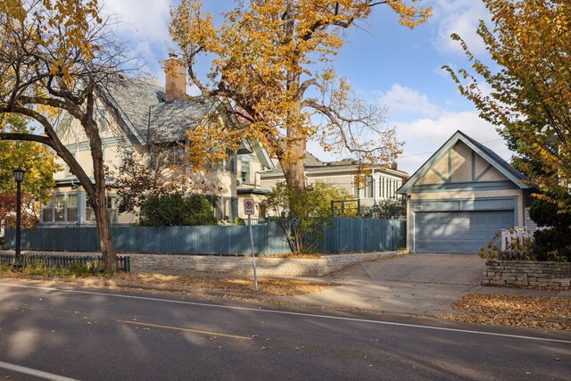 1941 James Ave S, Minneapolis, MN 55403 - obstructed view of property with a garage, a chimney, and concrete driveway